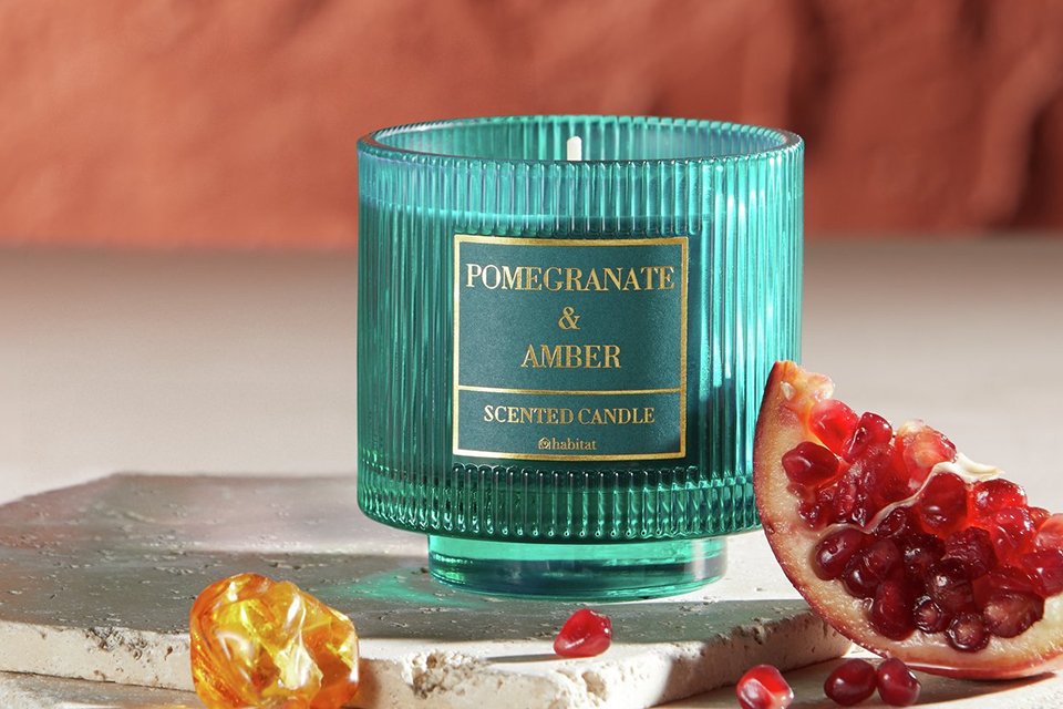 A Habitat scented boxed candle with pomegranate and amber fragrance.